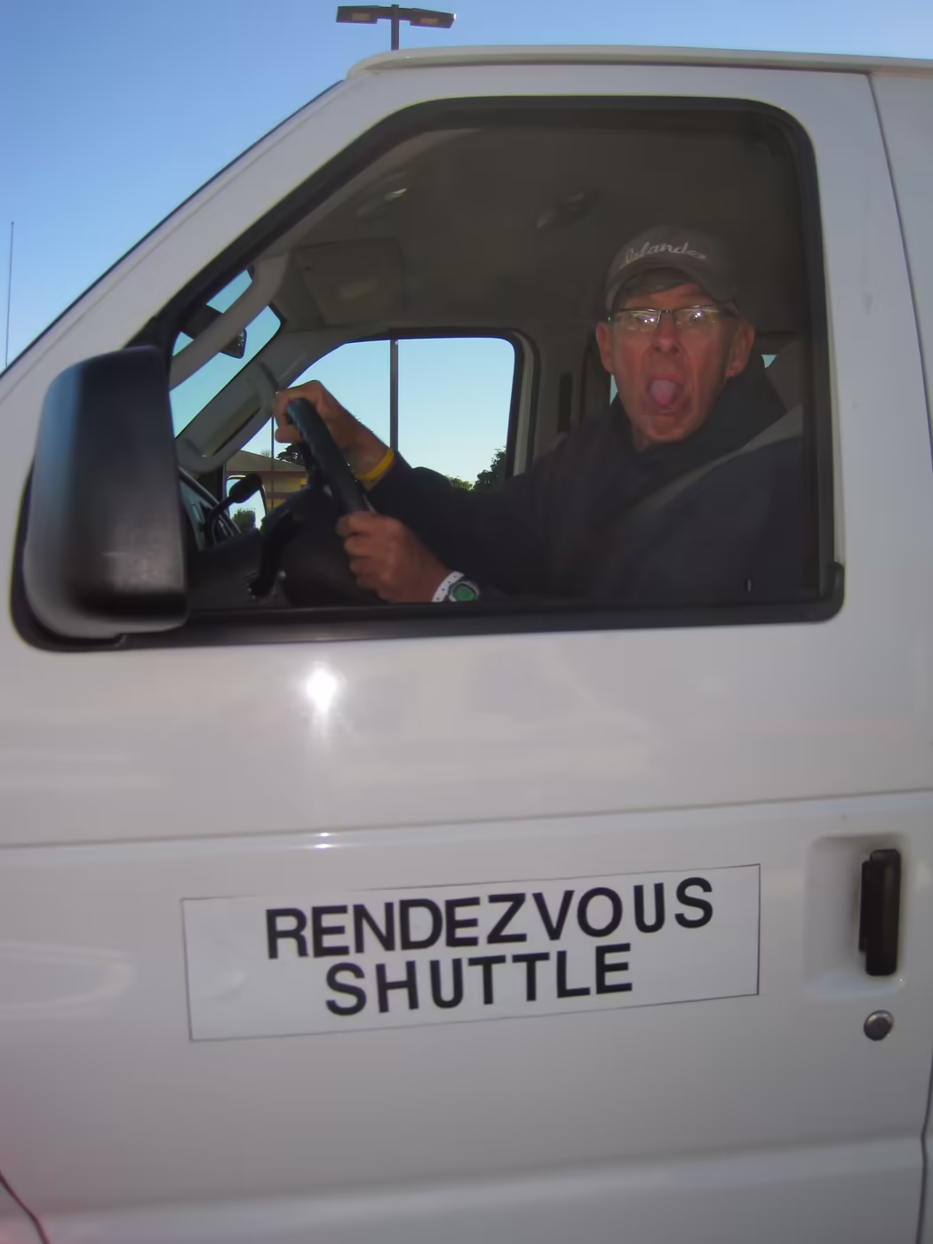 A volunteer grinning from the driver’s seat of the Rendezvous Shuttle